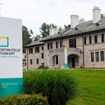 the museum - a stone two story building with a sign out front