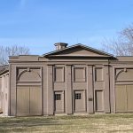 Wadsworth Stable “Front view of the historic Wadsworth Stable, a symmetrical brown wooden building with classical architectural details, large double stable doors, shuttered openings, and a central pediment.”